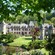 2 small castles near trees, a pond, a lawn and flowers